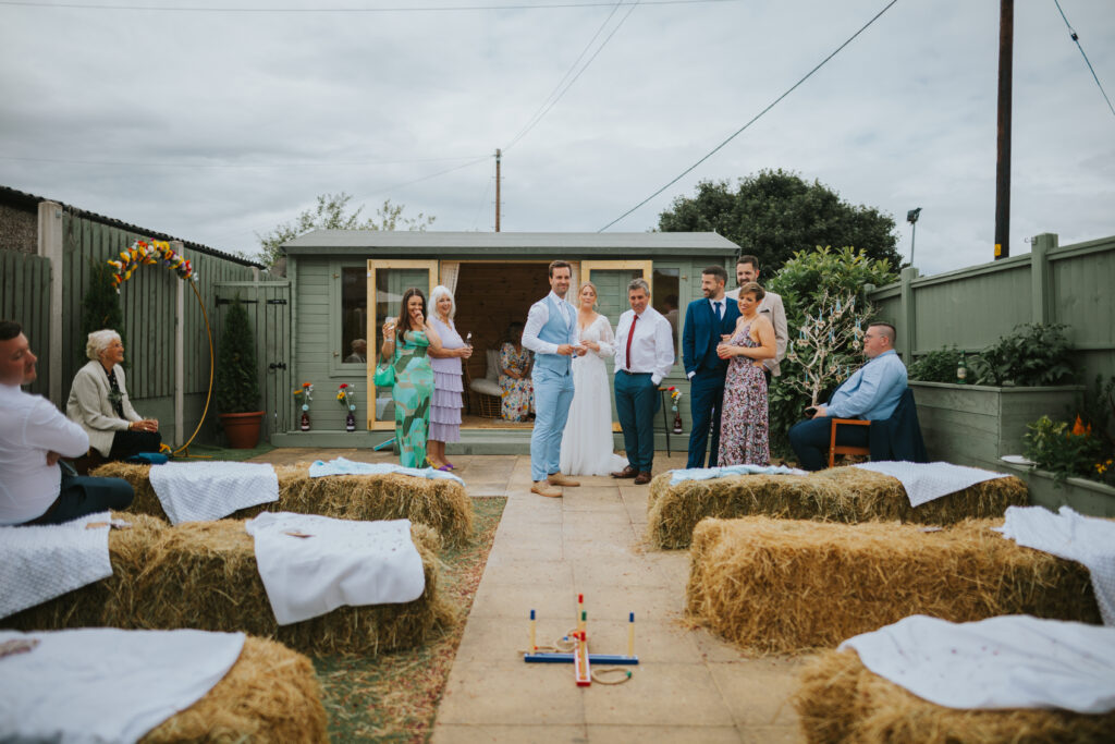 Guests enjoying games and laughter at a back garden wedding, highlighting the joy and casual atmosphere of a small, alternative outdoor celebration.