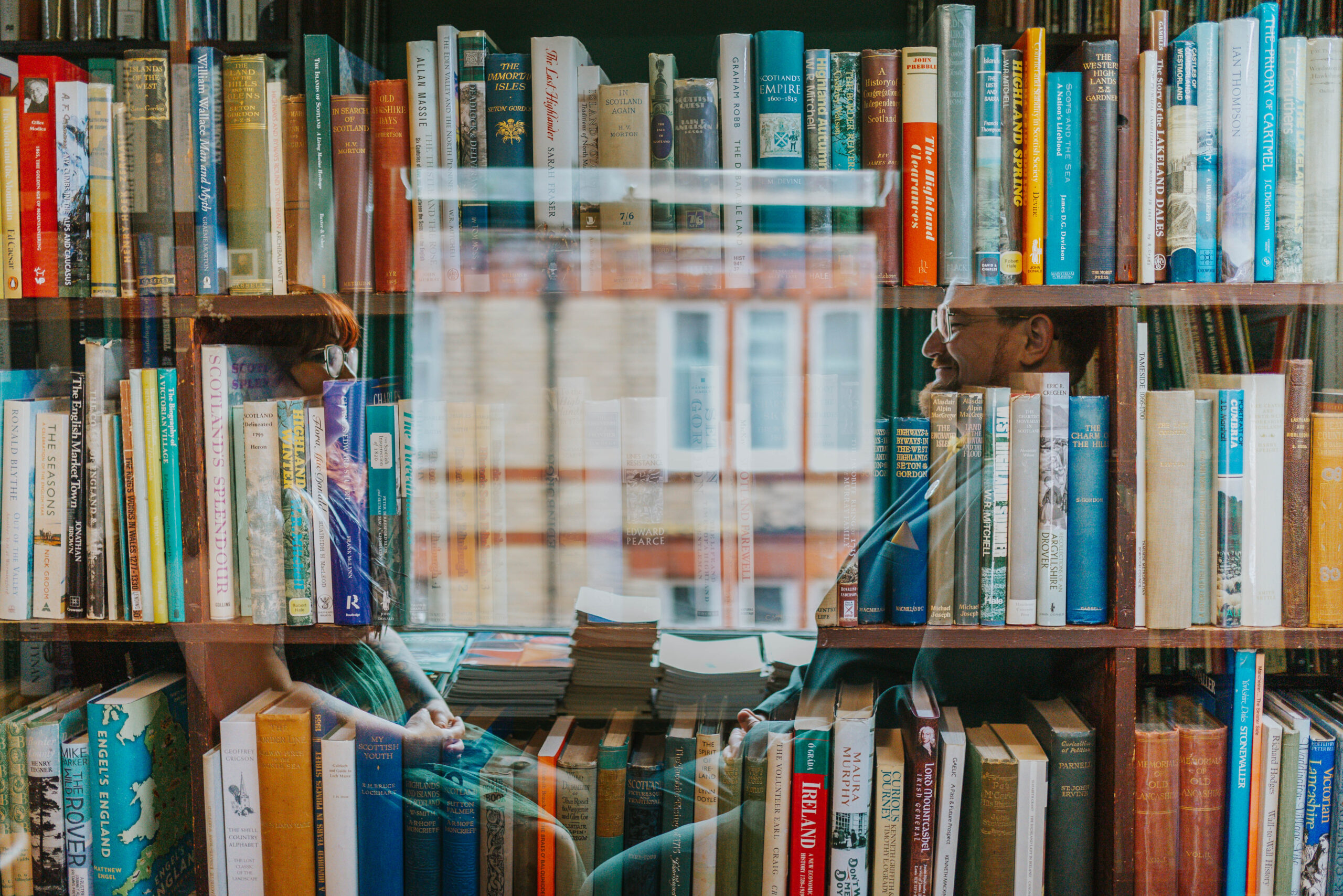 Romantic library wedding photo of a couple framed through book shelves, blending creativity and storytelling for a relaxed Yorkshire wedding photography session.