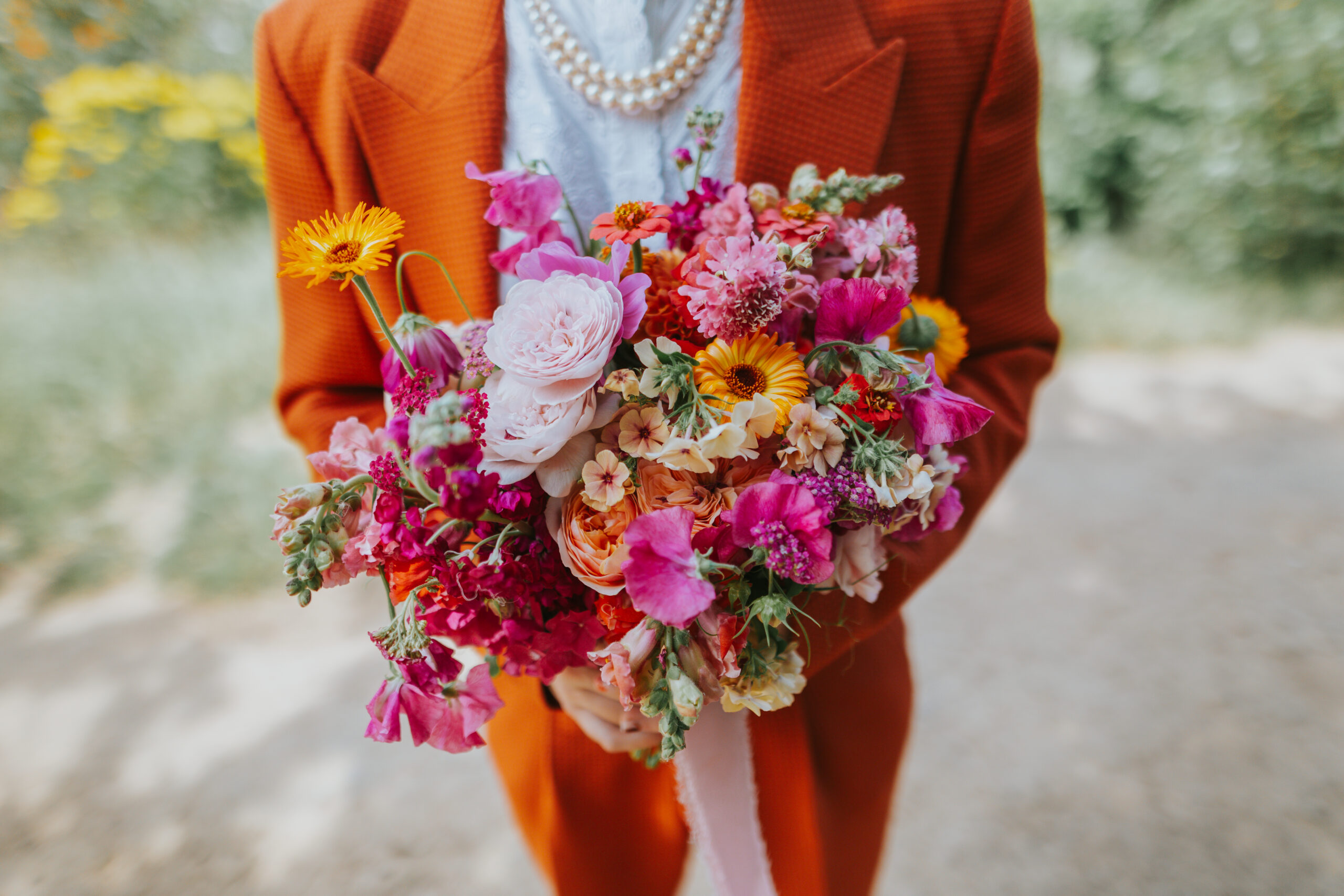 Groom at The Chilli Barn on his wedding day with a colourful bouquet by Leafy Couture Flowers. Photographed by Slate Cottage Studio.