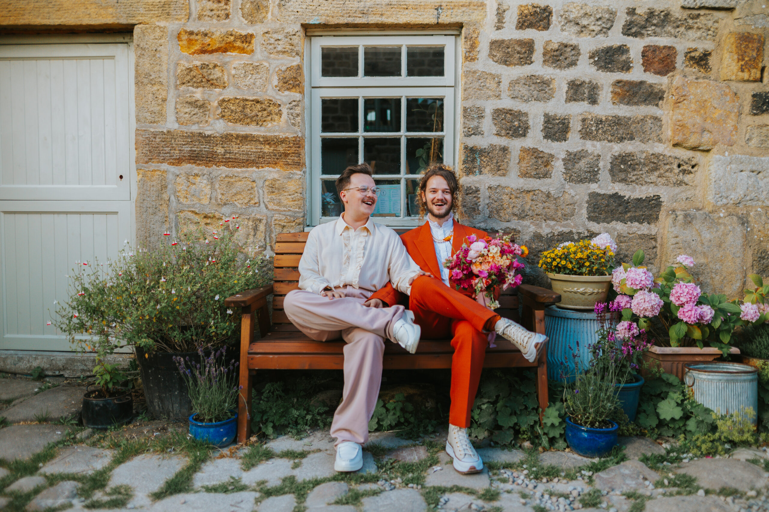 Couple at The Chilli Barn on their wedding day with a colourful bouquet by Leafy Couture Flowers. Photographed by Slate Cottage Studio, who guided the couple to achieve relaxed wedding photography