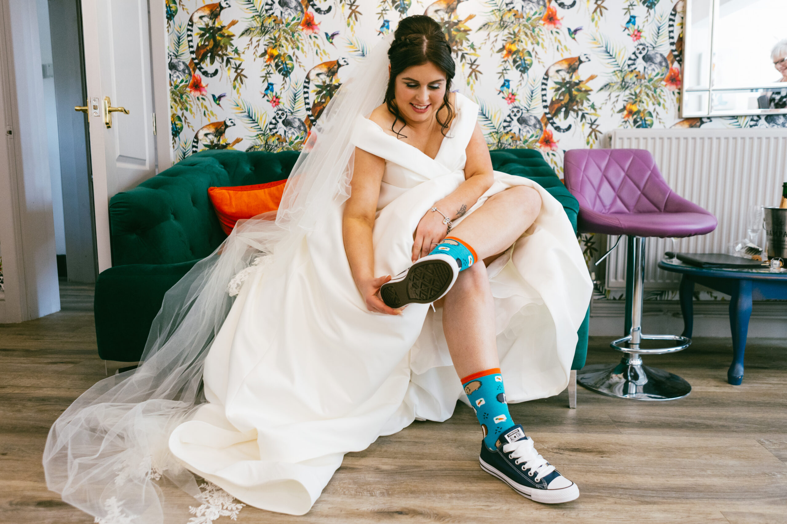 Bride wearing Converse trainers with her, wedding dress on her wedding day at The Wellbeing Farm, Bolton. Photographed by Slate Cottage Studio.